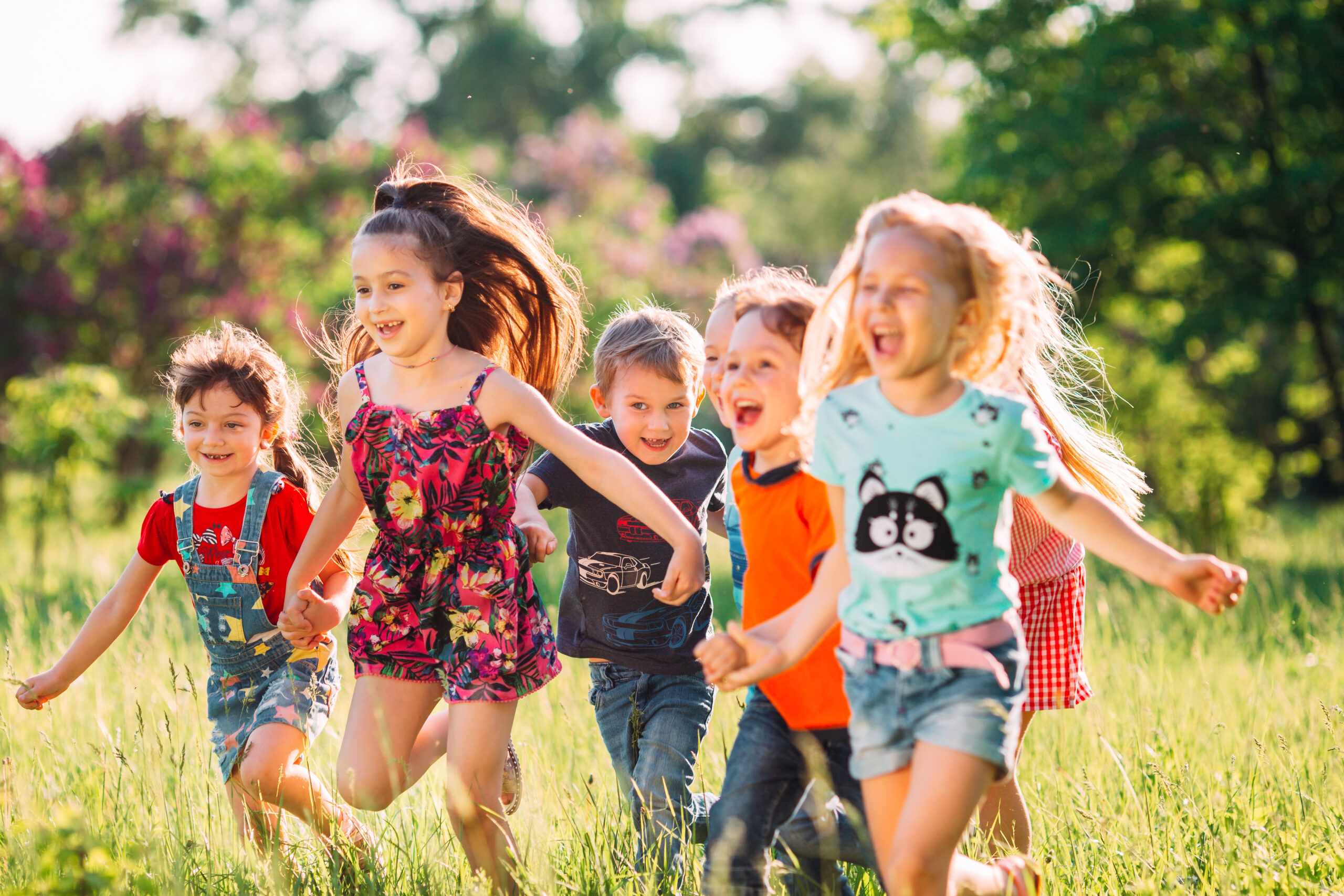 Large group of kids, friends boys and girls running in the park