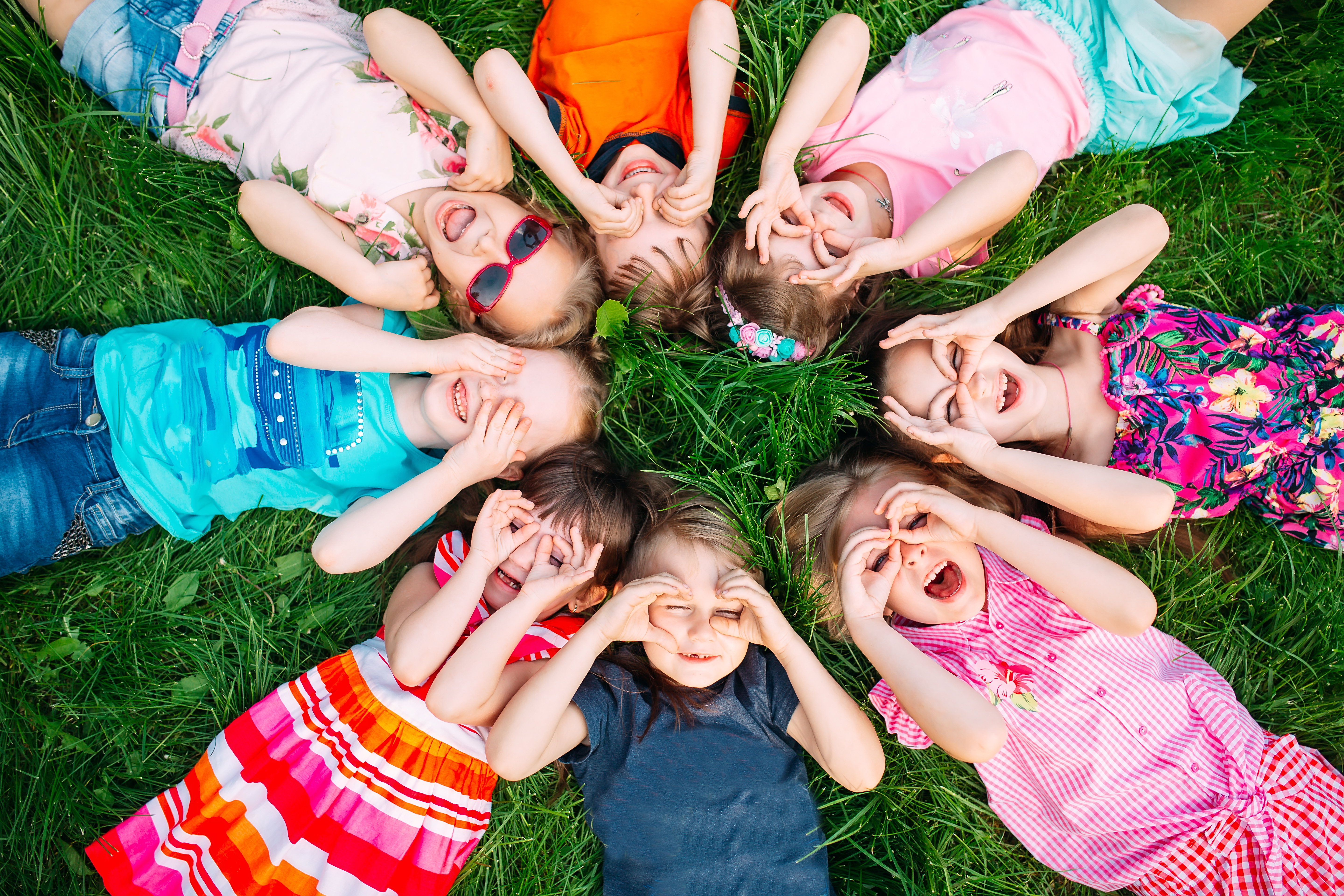 A group of children lying on the green grass in the Park.