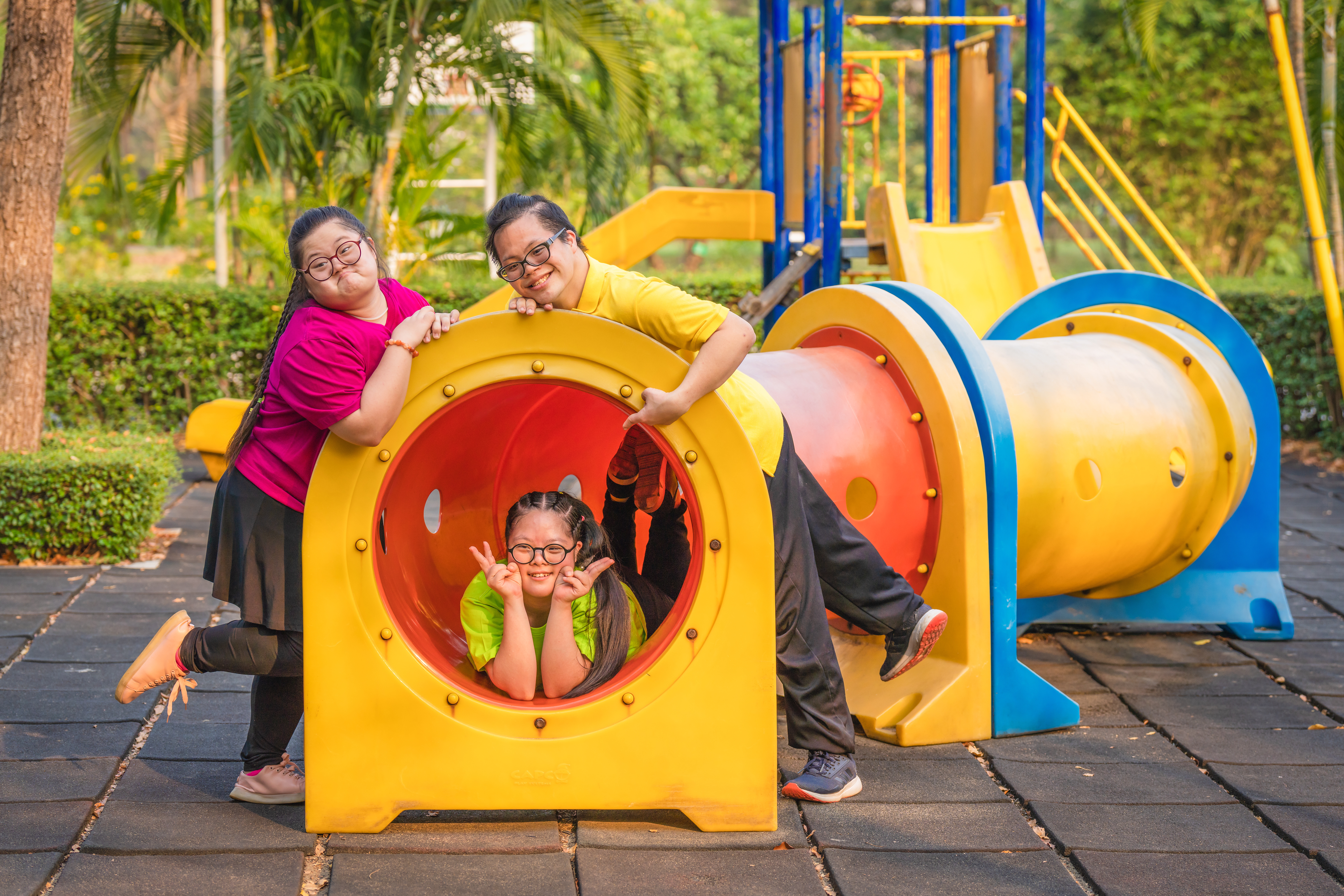 asian friends with autistic or down syndrome playing together at playground