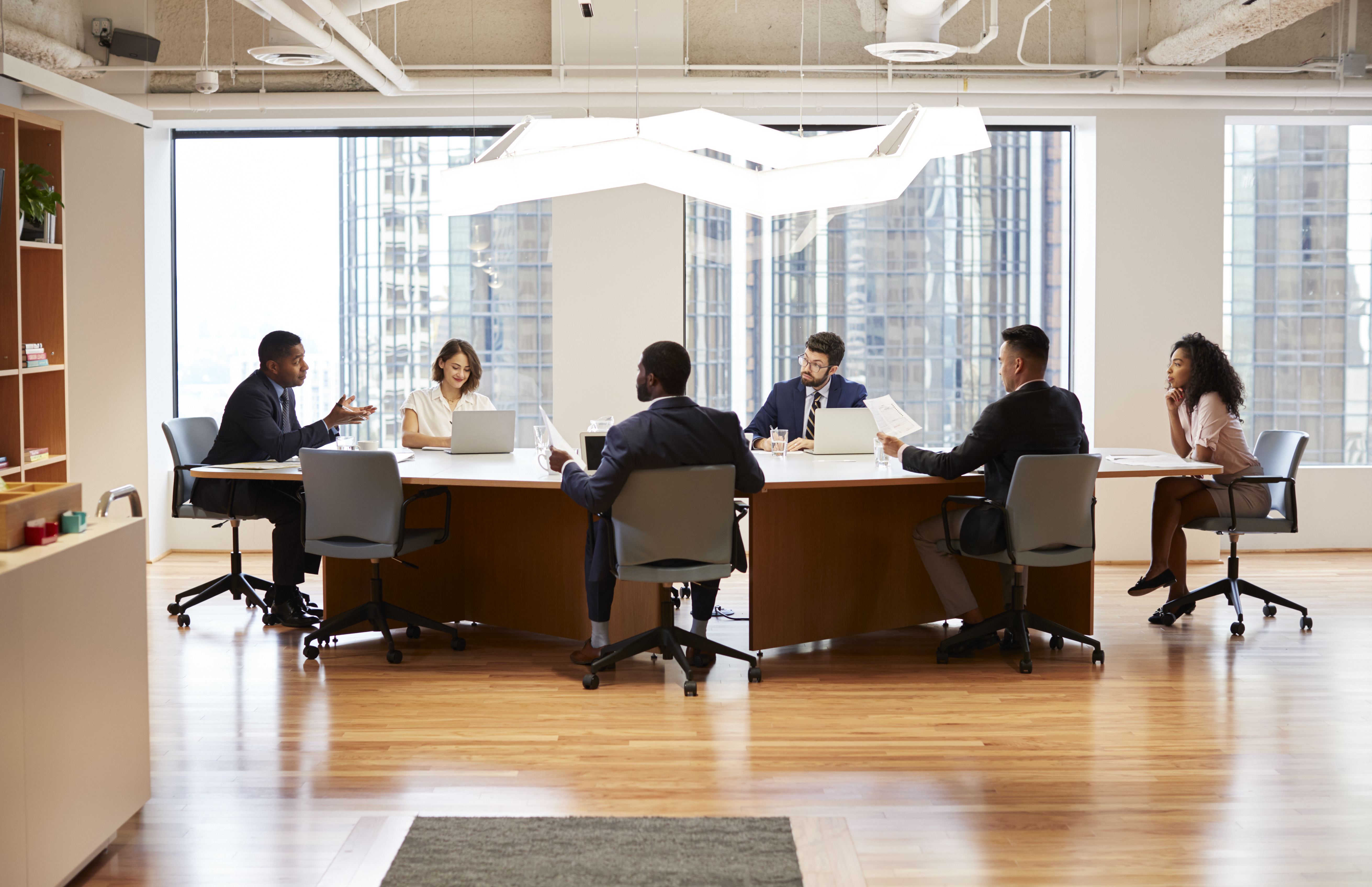 Group Of Business Professionals Meeting Around Table In Modern Office