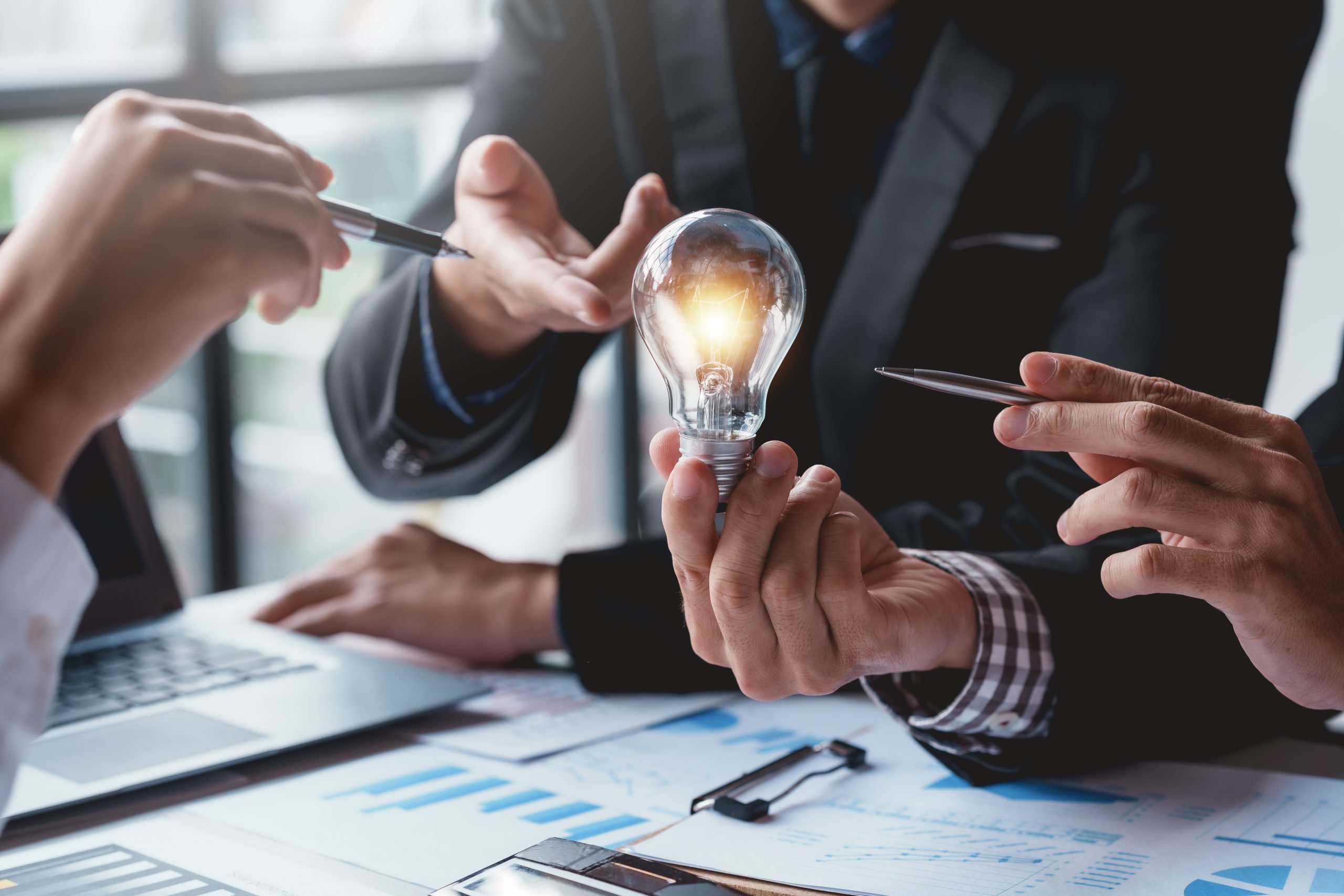 Group of business people pointing at light bulbs ideas for doing business concept.